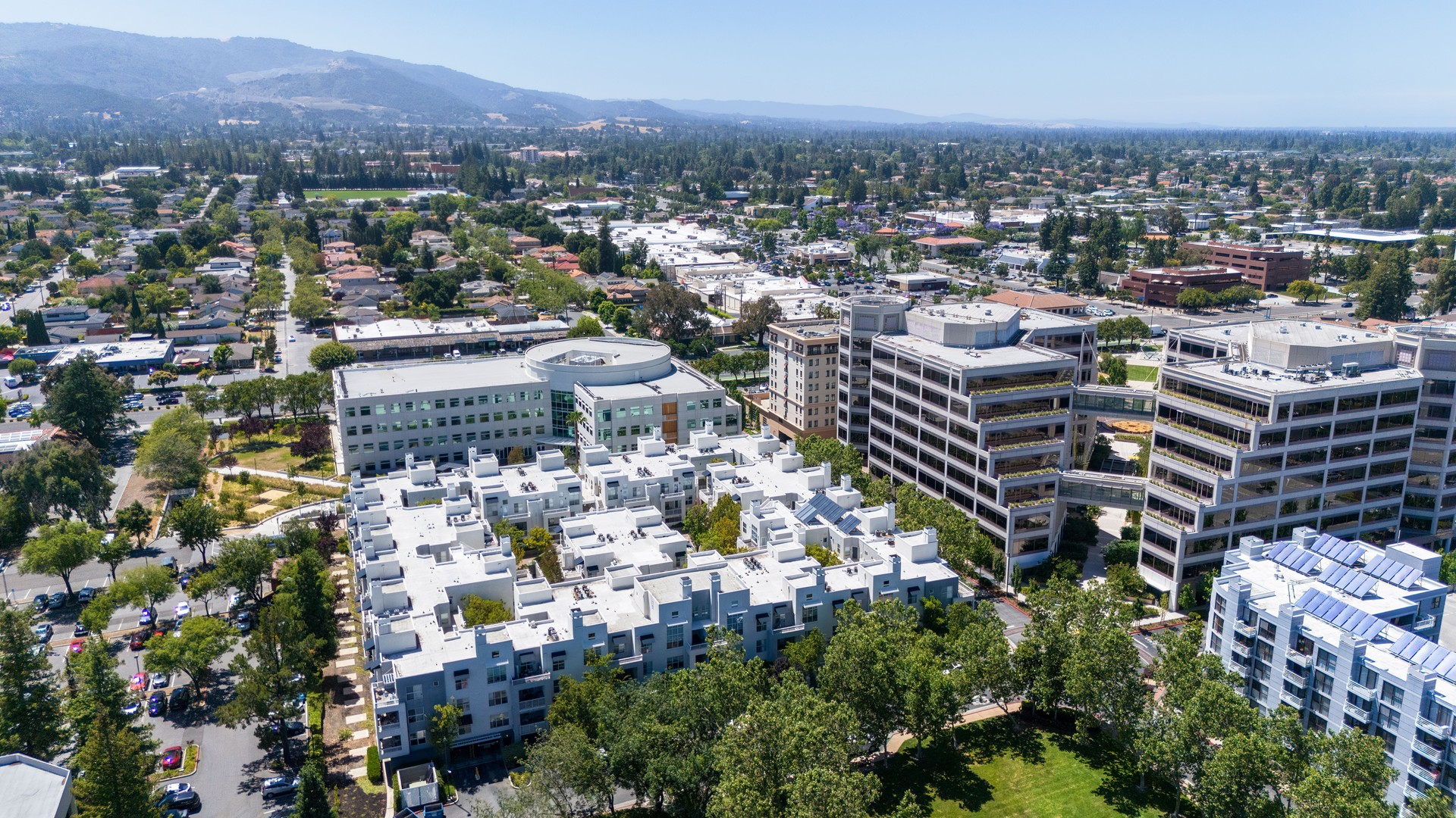 Green technology allows growing gardens on the rooftops and the buildings' terraces. Cupertino modern financial and technological cityscape blends residential structures in Silicon Valley, California at Santa Cruz foothills